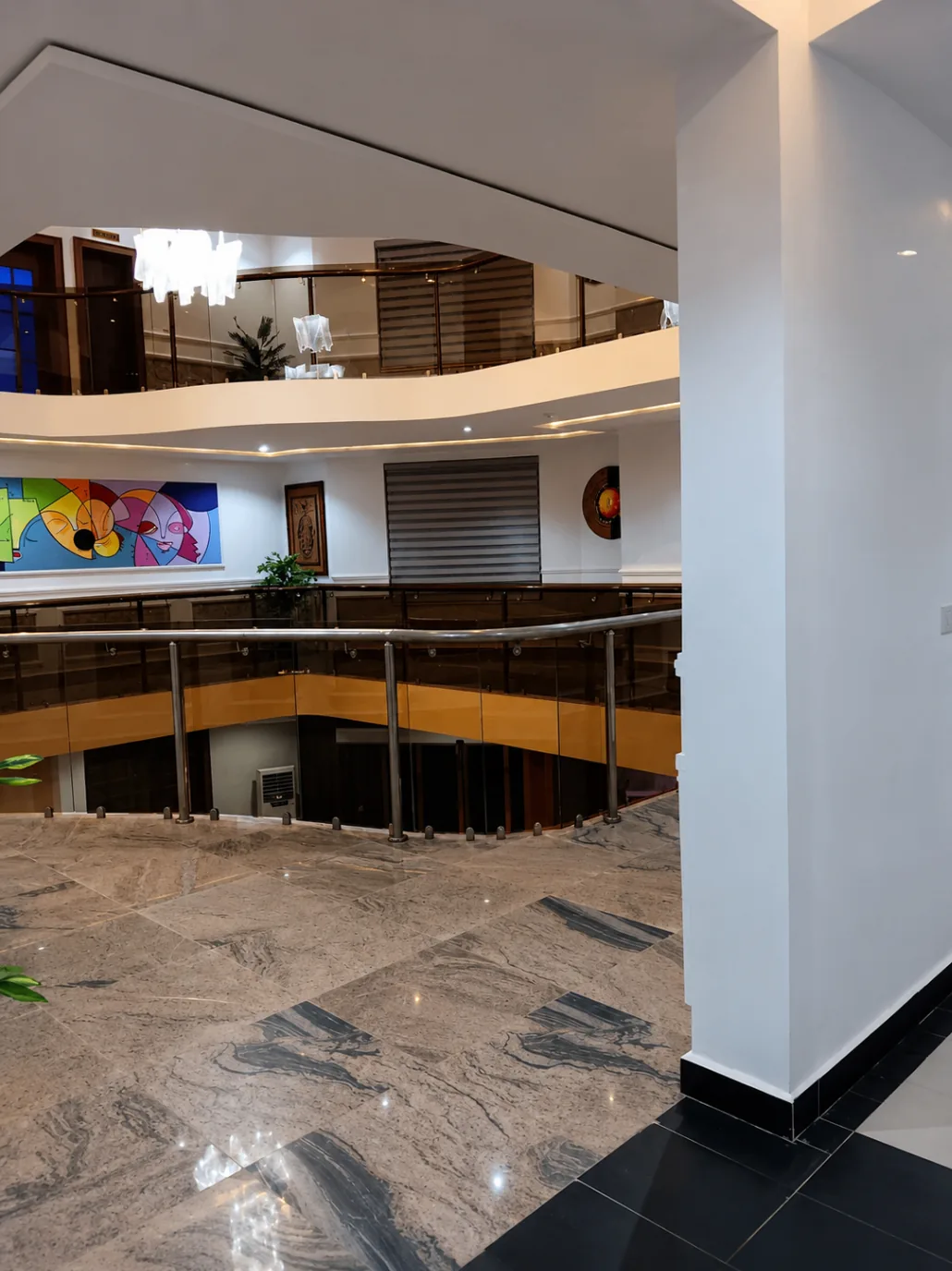 Marble-finished upper walkway with glass balustrade